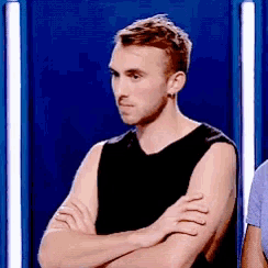 a man with his arms crossed is wearing a black shirt