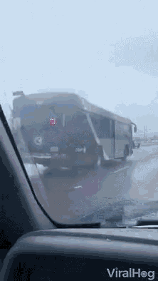 a bus is driving down a road with the word viralhog on the dash