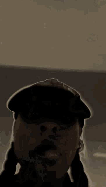 a man wearing a hat is smoking a cigarette