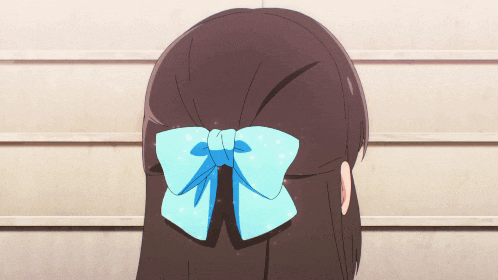 a girl with brown hair and a blue bow in her hair is making a funny face