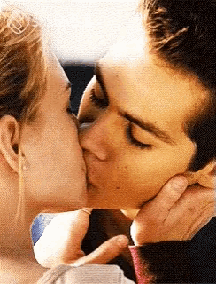 a man and a woman are kissing in a car .