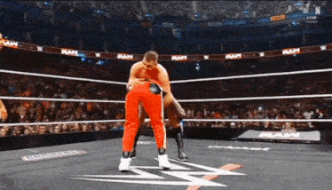 two men are wrestling in a wrestling ring with the word raw on the ropes