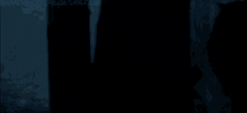 a silhouette of a person standing in a dark room in a dark room .