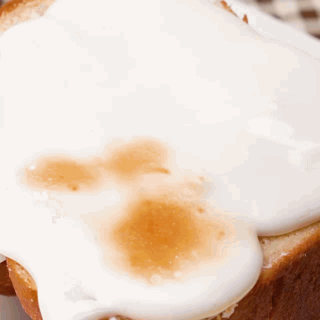 a close up of a piece of toast with syrup and whipped cream
