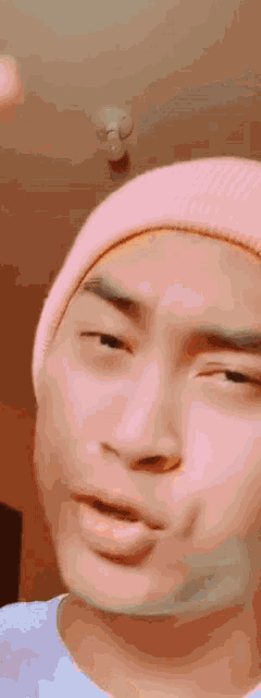 a close up of a person wearing a pink hat making a funny face .