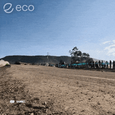 a group of people are standing on the side of a dirt road with the word eco on the bottom