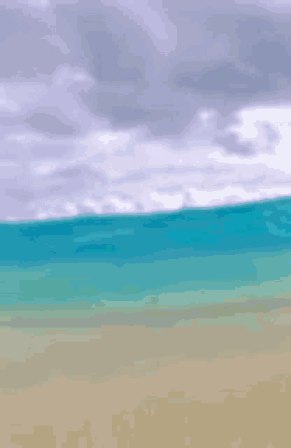 a painting of a beach with a turquoise ocean and a cloudy sky in the background .