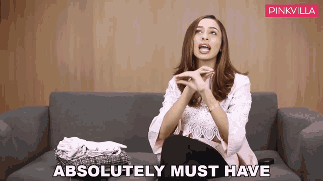 a woman sitting on a couch with the words " absolutely must have " on the screen