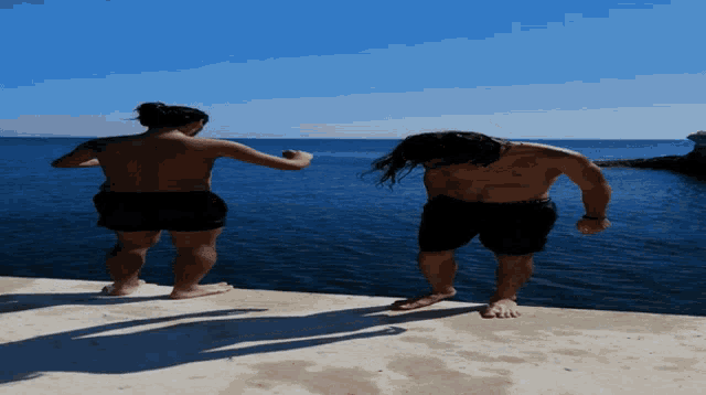 a man and a woman standing on a dock near the ocean