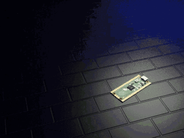 a small electronic device is laying on a black tiled floor