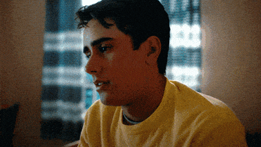 a young man wearing a yellow shirt is looking to the side
