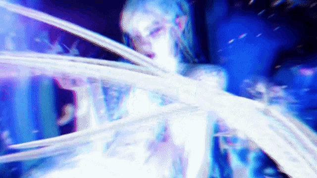 a woman in a white dress is standing in a dark room with a blue light coming out of her chest .