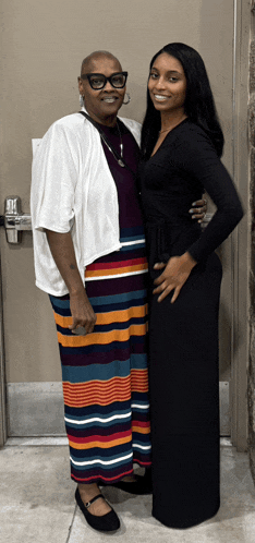 a woman in a striped skirt stands next to a woman in a black dress