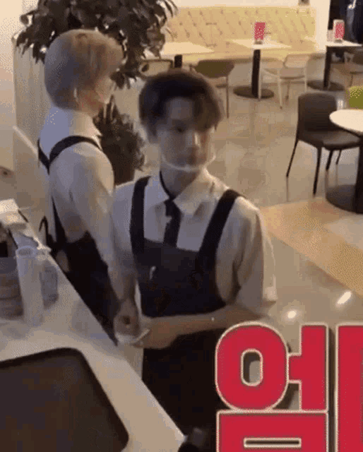 a man wearing a face mask is standing in a restaurant .