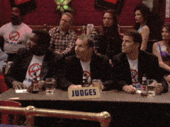 a group of men sit at a table with a sign that says judges on it