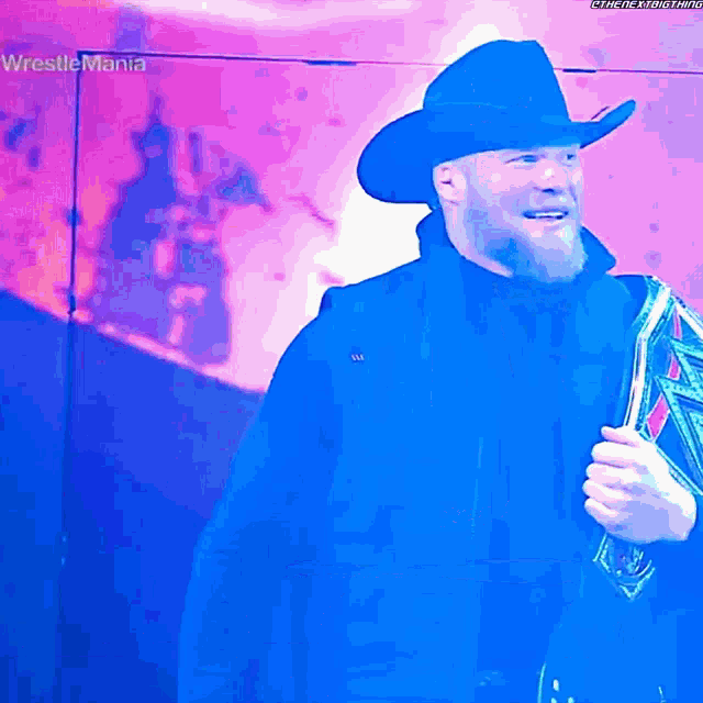 a man in a cowboy hat is holding a trophy in front of a sign that says wrestlemania on it