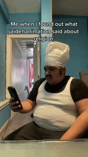 a man wearing a chef hat is looking at his cell phone