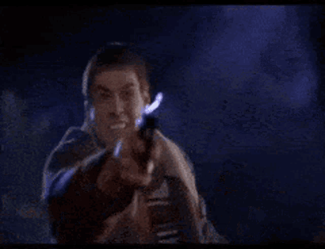 a man in a suit is holding a gun in his hand and screaming .