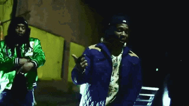 two men are standing next to each other and one of them is wearing a blue jacket