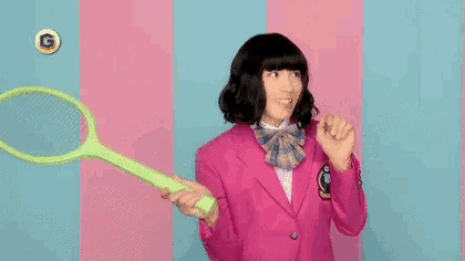 a woman in a pink suit is holding a tennis racquet and a tennis ball .