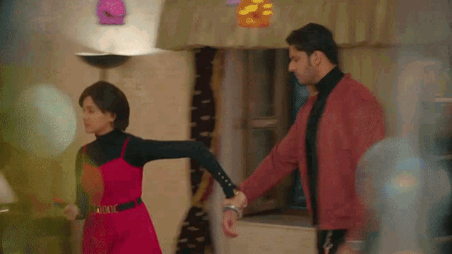 a man and a woman are holding hands and dancing in a room