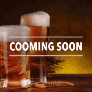 two glasses of beer are sitting on a wooden table with a sign that says coming soon