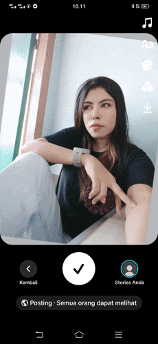 a phone screen shows a woman sitting on the floor