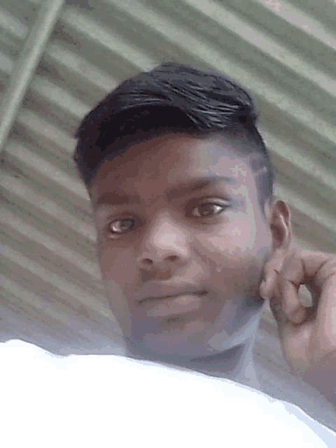 a young man holds his hand to his ear