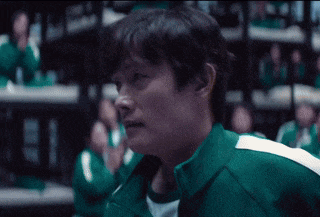 a man in a green jacket stands in front of a crowd