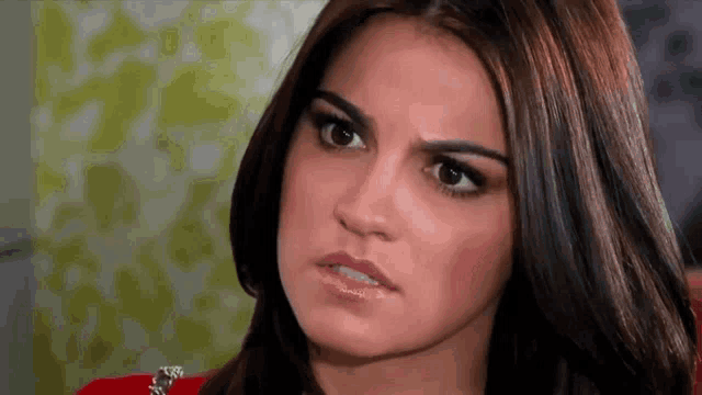 a close up of a woman 's face with a slight smirk on her face