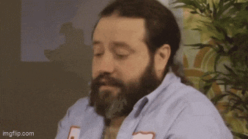 a man with a beard is wearing a blue shirt with the number 5 on the front .