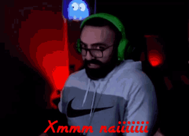 a man wearing headphones and a nike shirt says xmmm naiiii