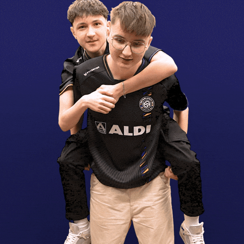 a man wearing an aldi shirt is carrying another man on his shoulders