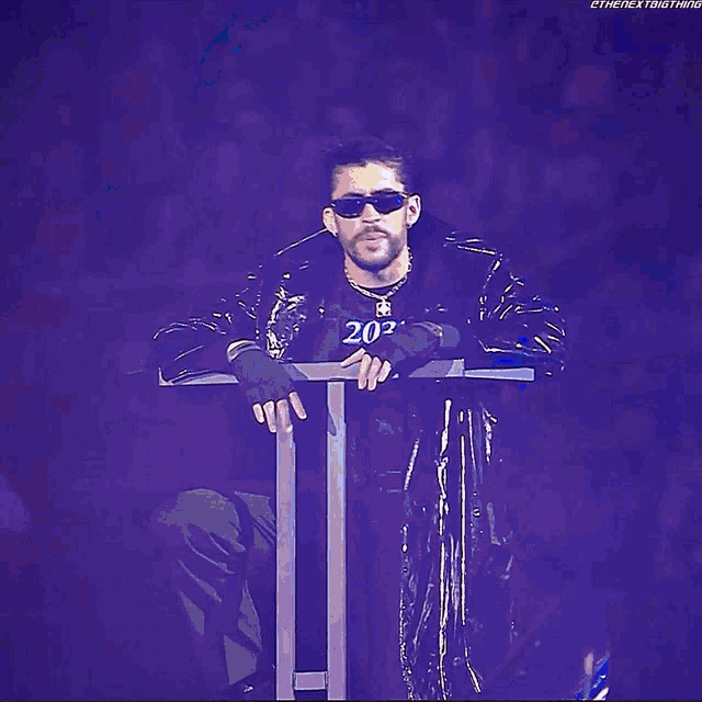 a man wearing sunglasses and a black shirt that says 2030