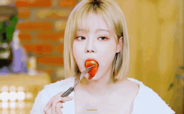 a woman eating a piece of food with a fork