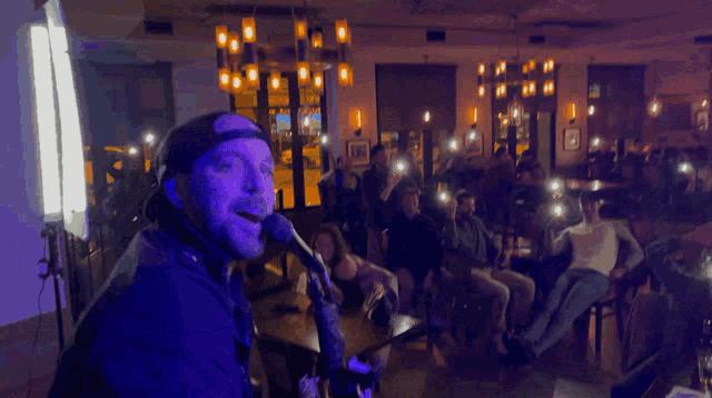 a man singing into a microphone in a dark room