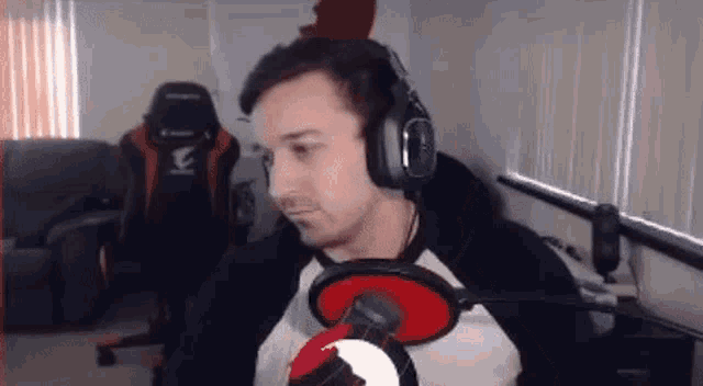 a man wearing headphones and a microphone is sitting in front of a microphone .