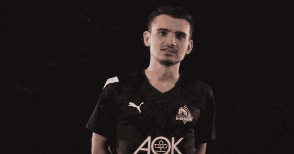 a man wearing a black shirt with aok written on it