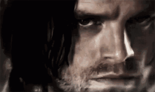 a close up of a man 's face with smoke coming out of his nose .