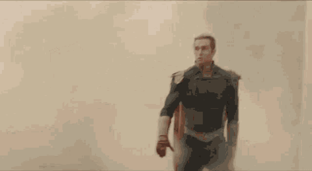 a man in a superhero costume is standing in the middle of a smokey area .