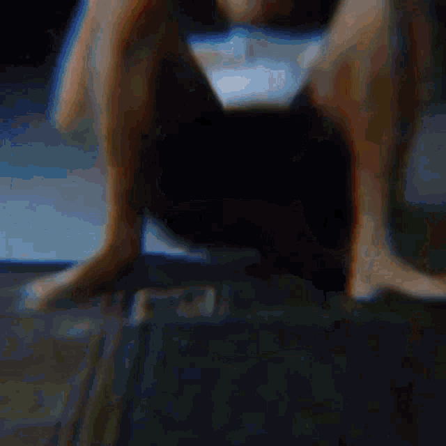 a person 's legs are visible in a blurry photo while sitting on a wooden floor .
