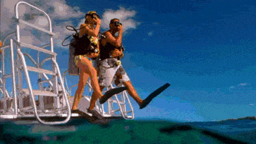 a man and a woman are getting ready to scuba dive in the ocean