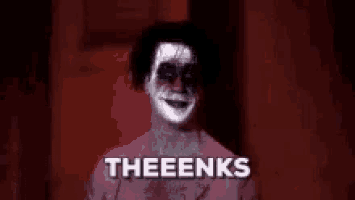a creepy clown with white paint on his face is standing in a dark room and saying theeenks .