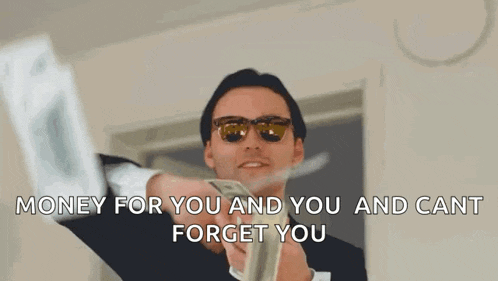 a man in a suit and sunglasses is holding a pile of money .