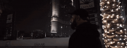 a man with a beard wearing a hat and a black hoodie with the letter l on it