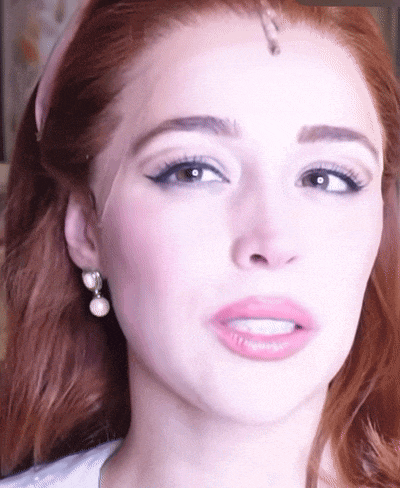 a close up of a woman 's face wearing earrings and a headband