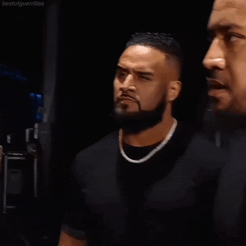 two men are standing next to each other and one has a beard