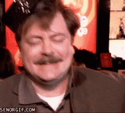 a man with a mustache is smiling with his eyes closed in front of a sign that says senorgif.com