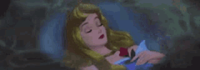 aurora from sleeping beauty is holding a heart in her hand while sleeping in the woods .