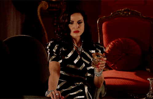 a woman in a striped dress holds a glass of wine